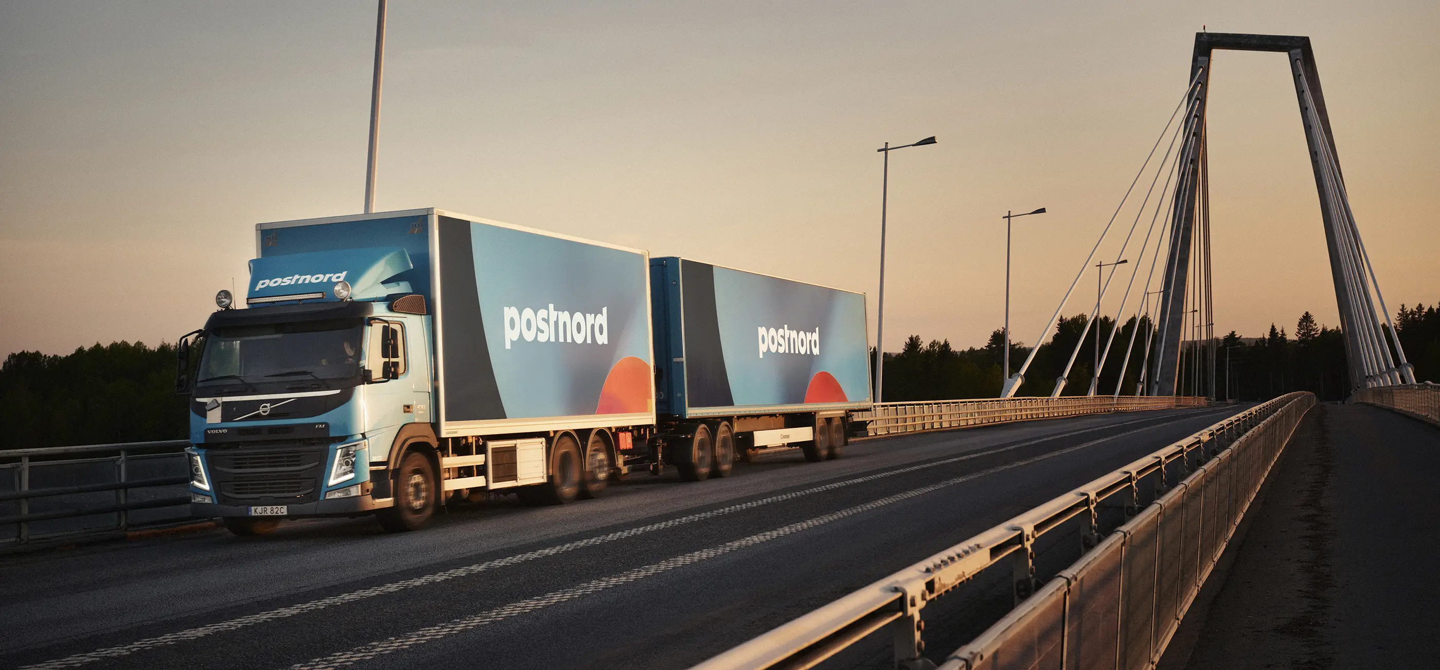 Truck drinving on bridge. The truck is a blue PostNord car.
